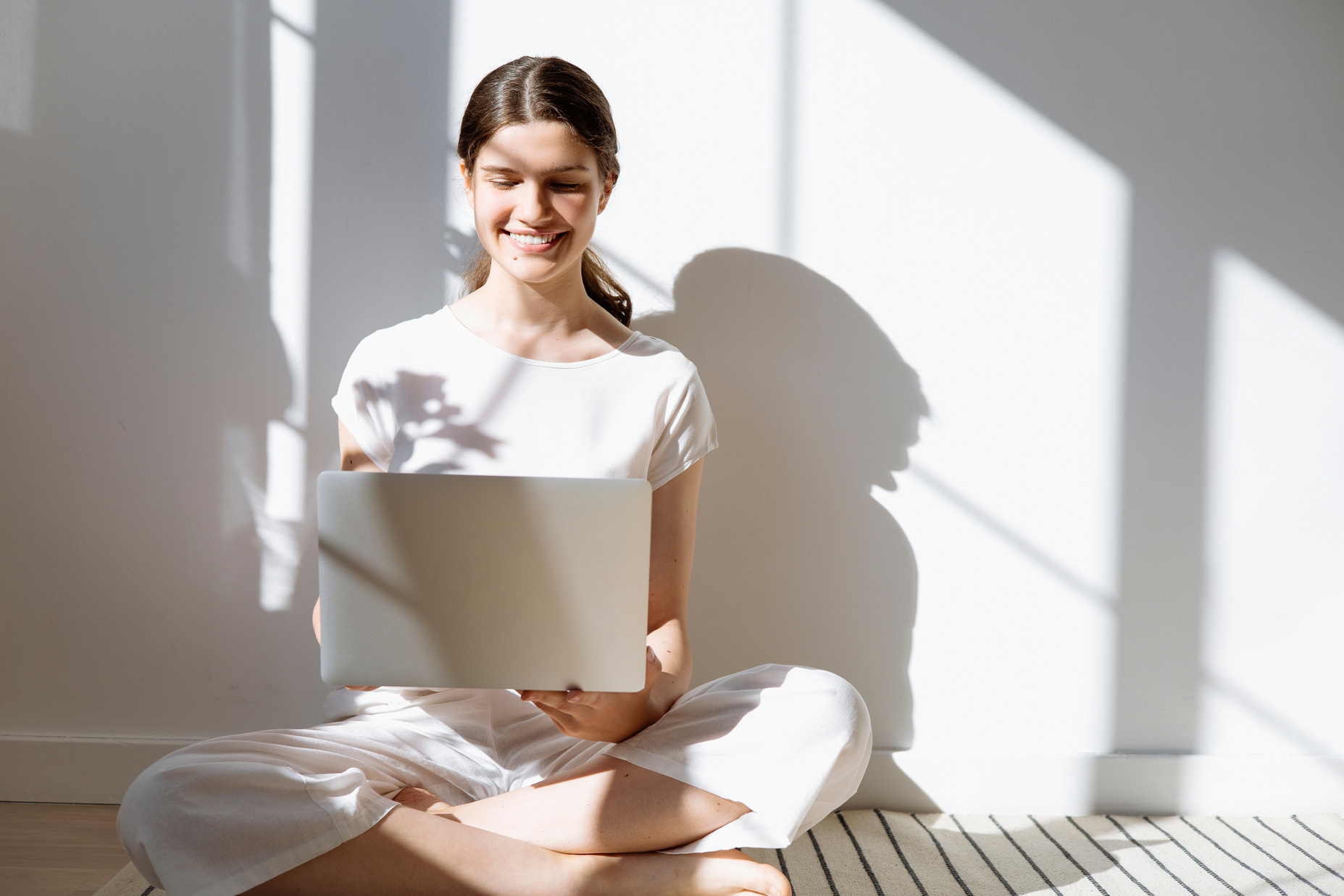 Woman in White Shirt Holding a White Laptop